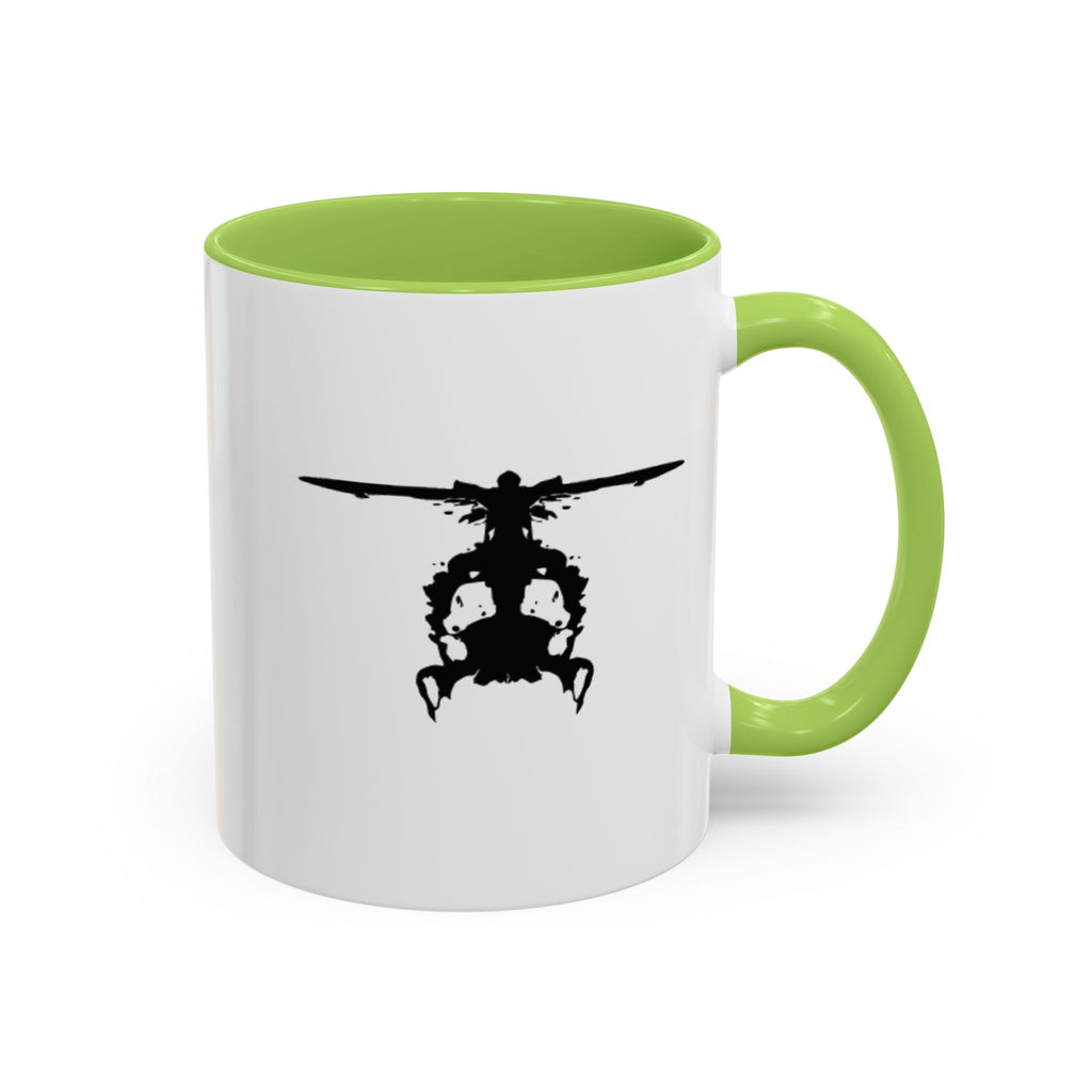 White mug with green handle and interior, featuring a black inkblot helicopter design on a white background