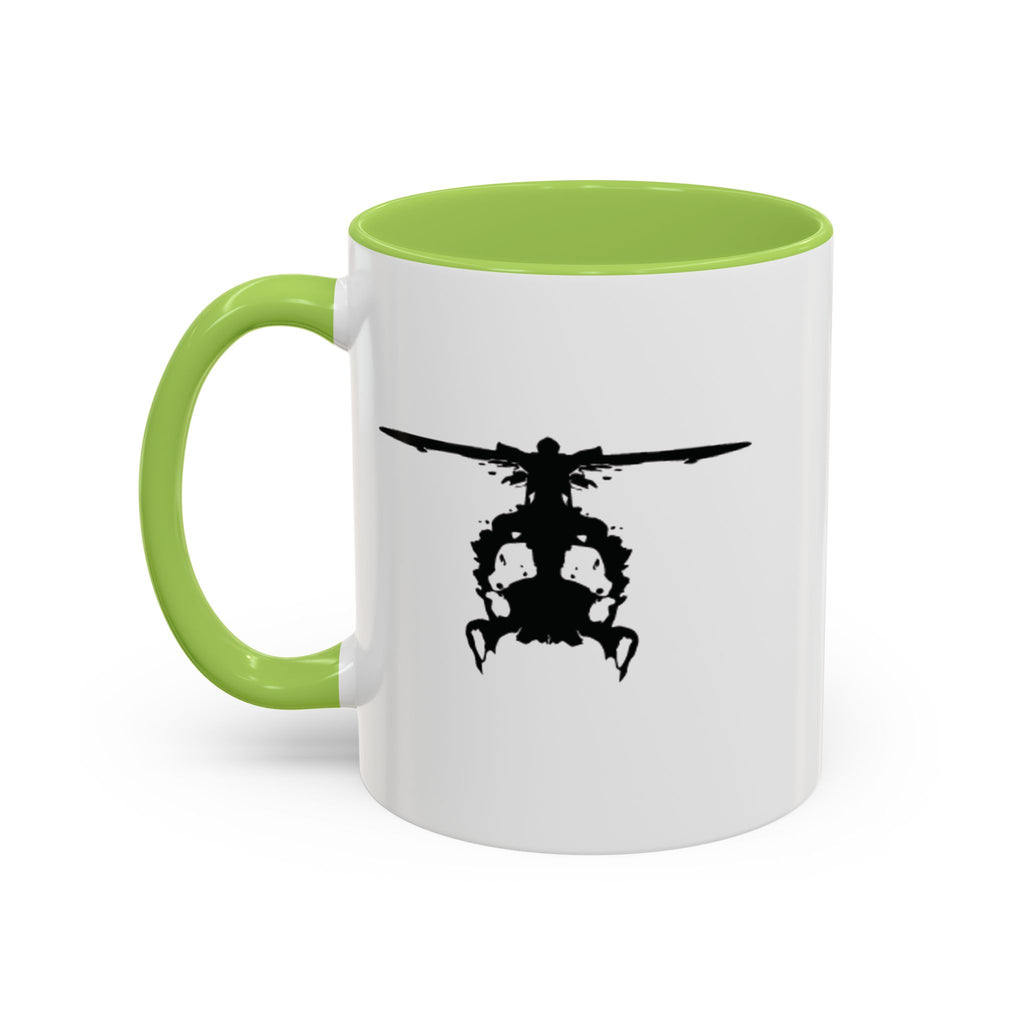 White mug with green handle and interior, featuring a black inkblot helicopter design on a white background
